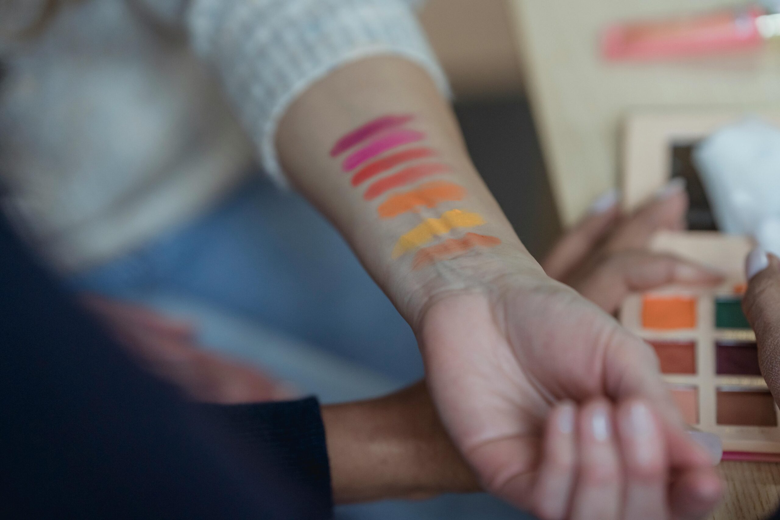 Swatches of vibrant eyeshadow colors laid out neatly on white paper