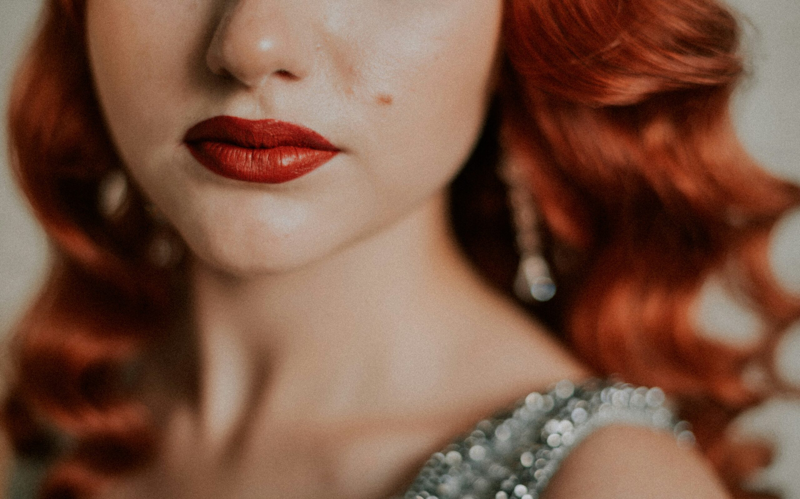 A model wearing bold red lipstick and winged eyeliner created using only drugstore makeup products