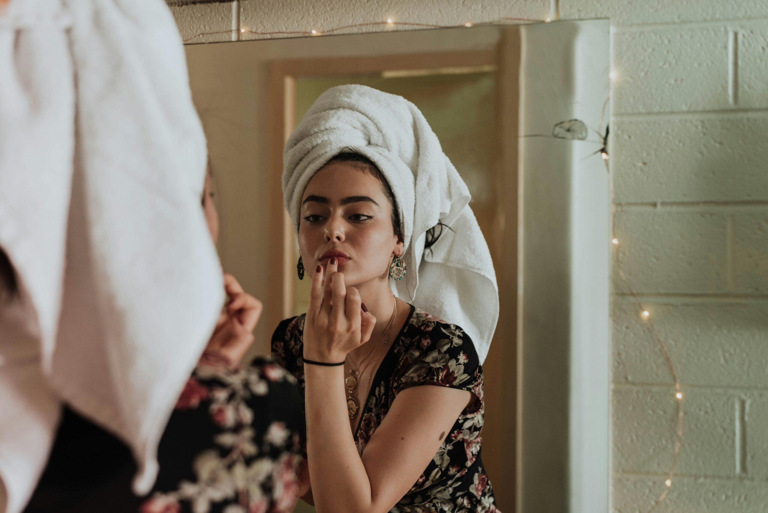 Woman applying mascara in mirror