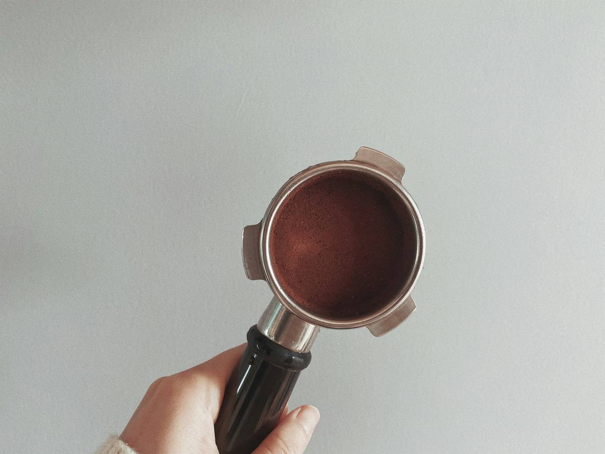 A makeup artist applying bronzer with a large brush on a model's cheekbones.