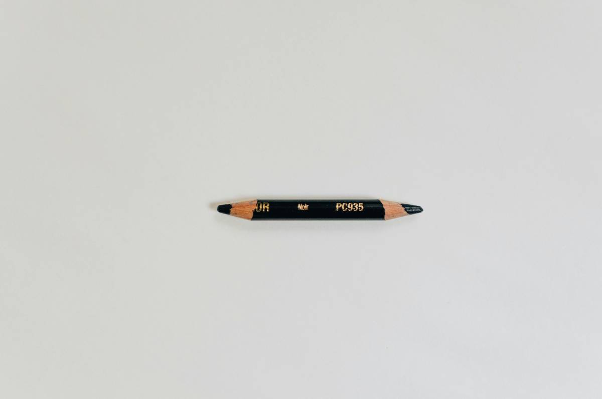 A close-up image of a drugstore economy eye pencil on a makeup palette