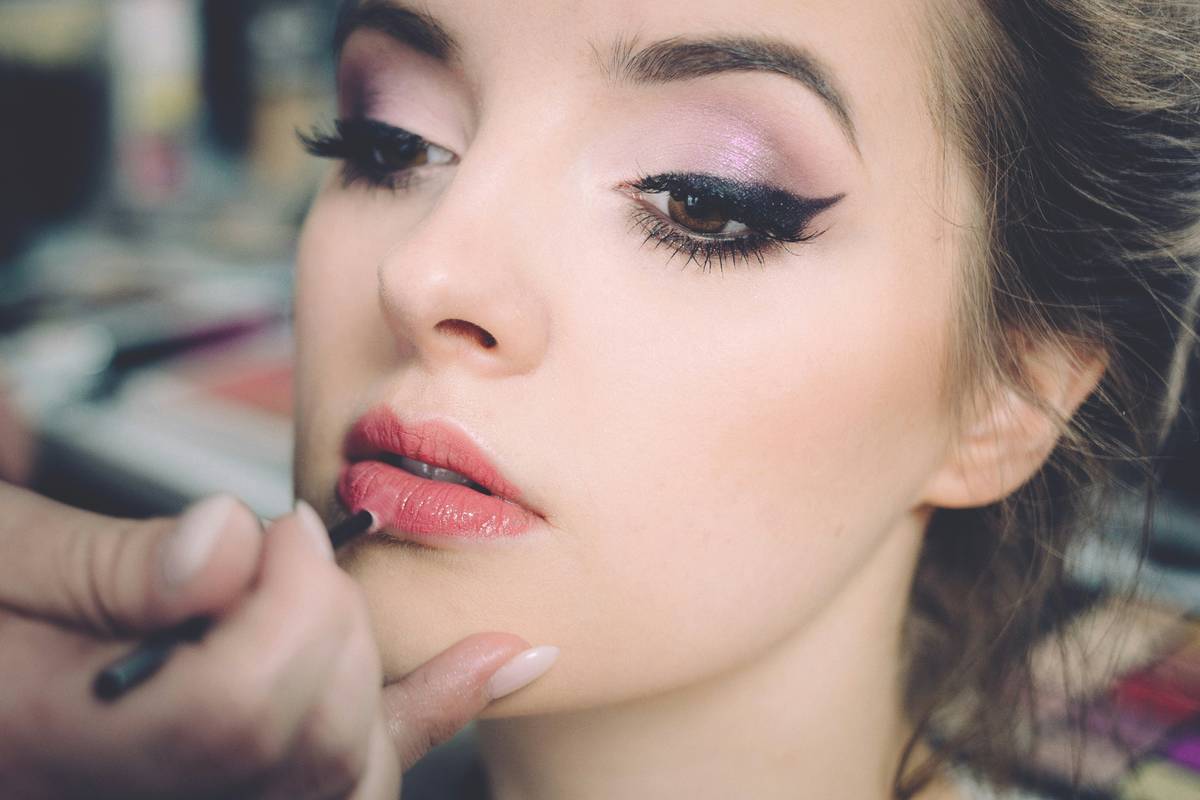 A woman applying moisturizer before starting her makeup routine.