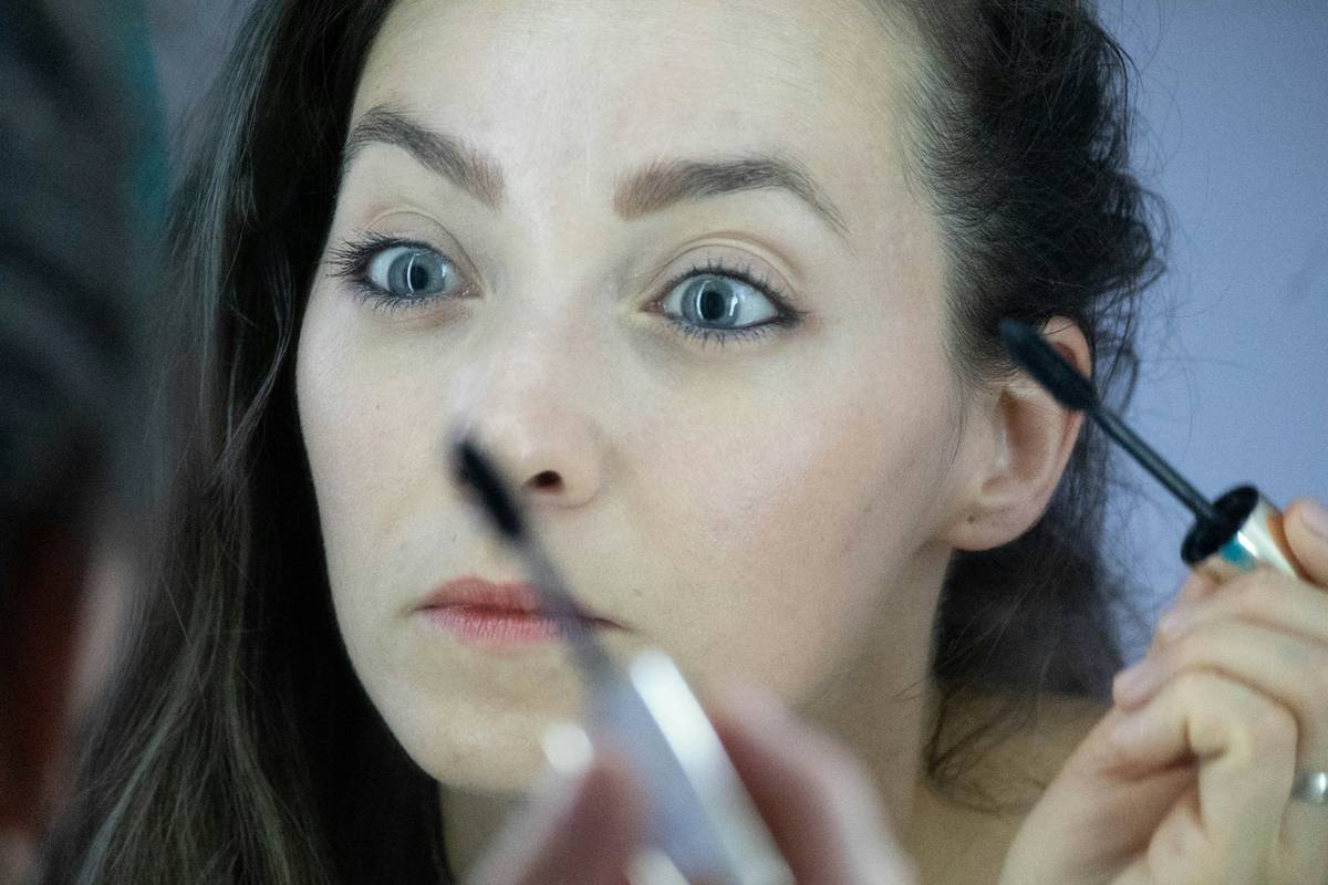 Woman applying concealer under eyes to hide dark circles