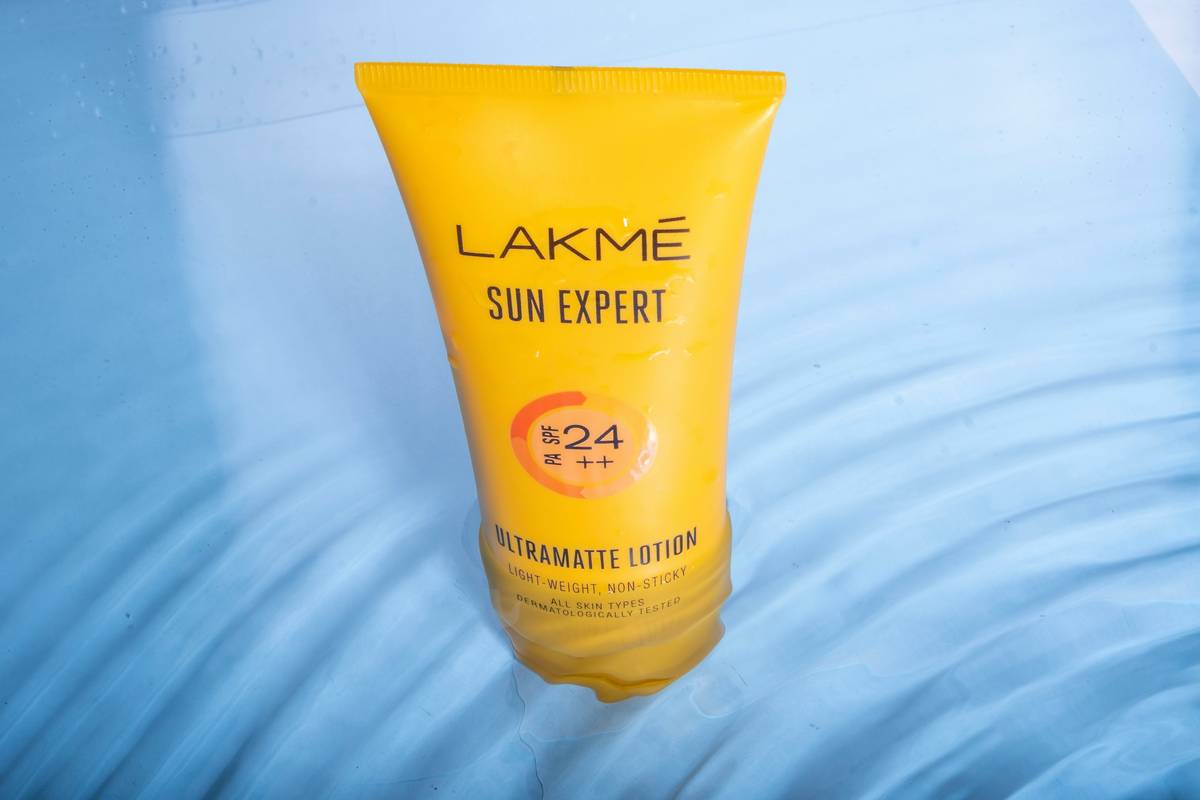 A woman applying daily sunscreen before her makeup routine